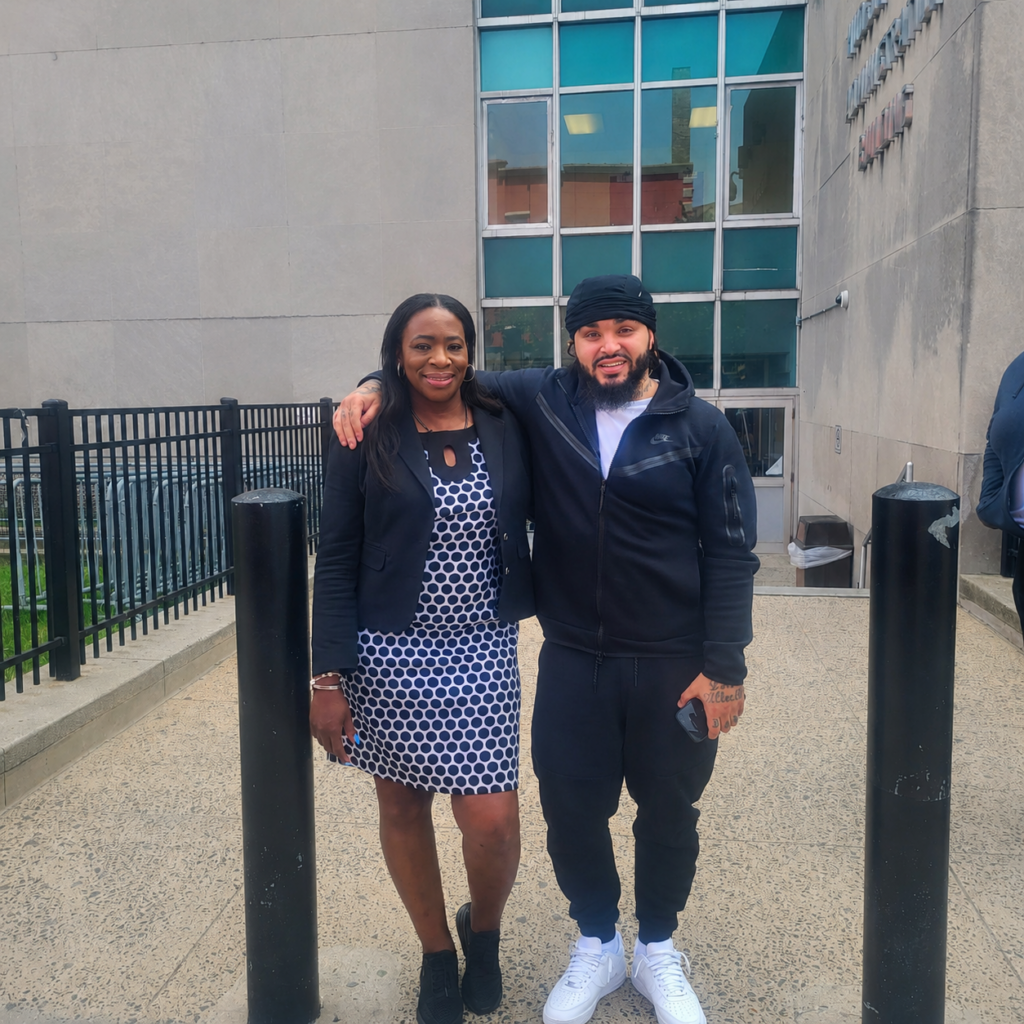Attorney Adrienne D. Edward stands with a client outside.